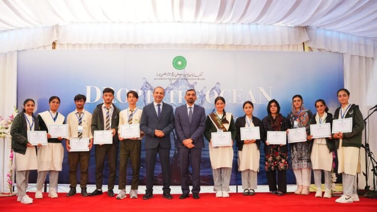AKU-EB High Achievers 2025 ceremony in Gilgit showing students, educators, and guests gathered on stage under the banner “You Are a Drop in the Ocean,” celebrating academic excellence and youth empowerment.