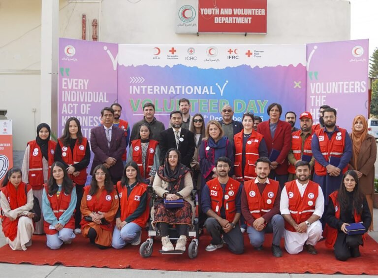 PRCS volunteers and leaders marking International Volunteer Day at a ceremony.