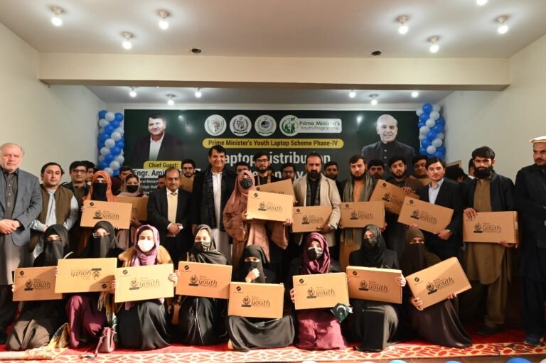 Prime Minister Laptop Distribution Program ceremony at Abdul Wali Khan University Mardan with students and officials in attendance.