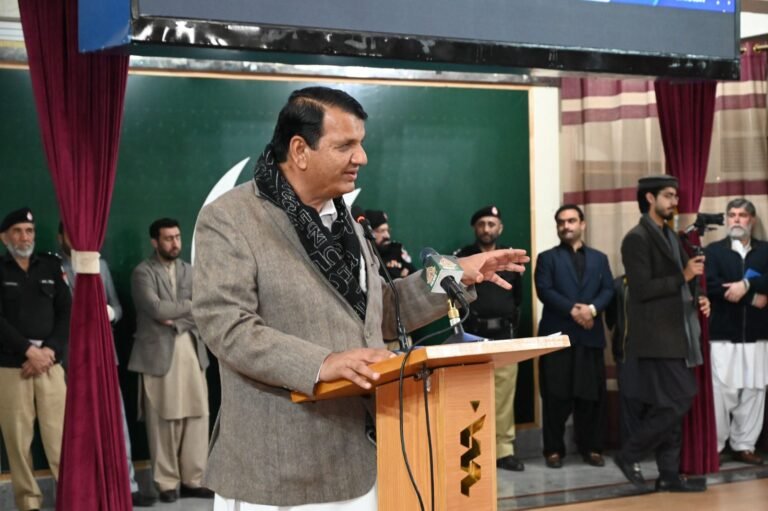 Federal Minister Amir Muqam addresses KMU Peshawar ceremony on merit-based laptop scheme.