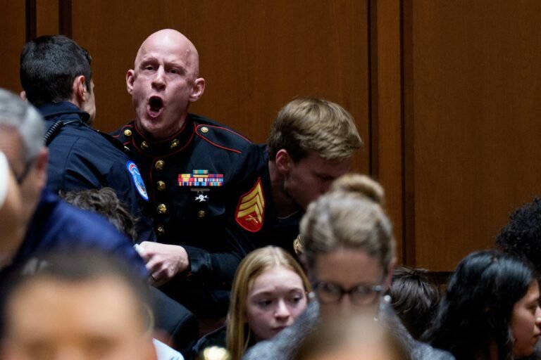 U.S. Marine veteran Brian McGinnis being escorted out of a Senate Armed Services hearing after an anti-war protest.