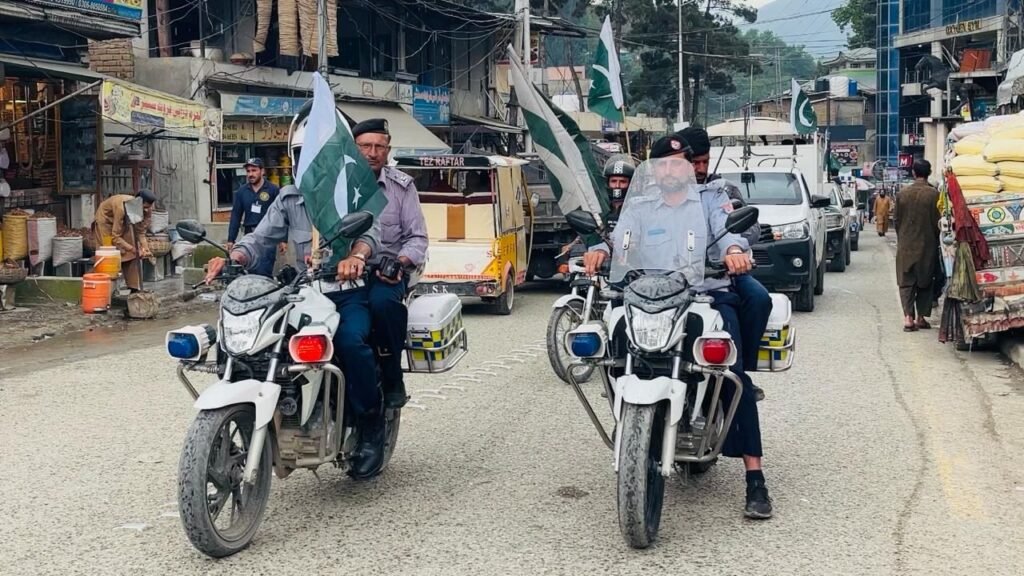 Upper Dir Police officers participate in a flag march marking the anniversary of Ma’arka-e-Haq victory