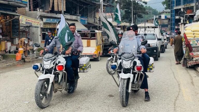 Upper Dir Police officers participate in a flag march marking the anniversary of Ma’arka-e-Haq victory