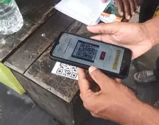 Consumers registering under Pakistan's QR code electricity subsidy system for power tariff verification.