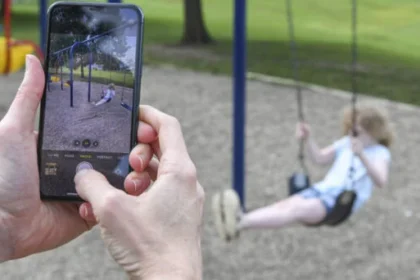 A parent using a smartphone to review privacy settings before sharing a child's photo online.