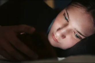 A teenager uses social media as the UK proposes a night-time social media curfew for young users.