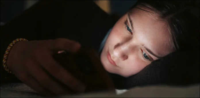 A teenager uses social media as the UK proposes a night-time social media curfew for young users.