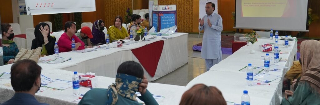 RTS Commission District Monitoring Officer Tashfin Israr addresses transgender community members at a Blue Veins workshop in Peshawar on public service rights.