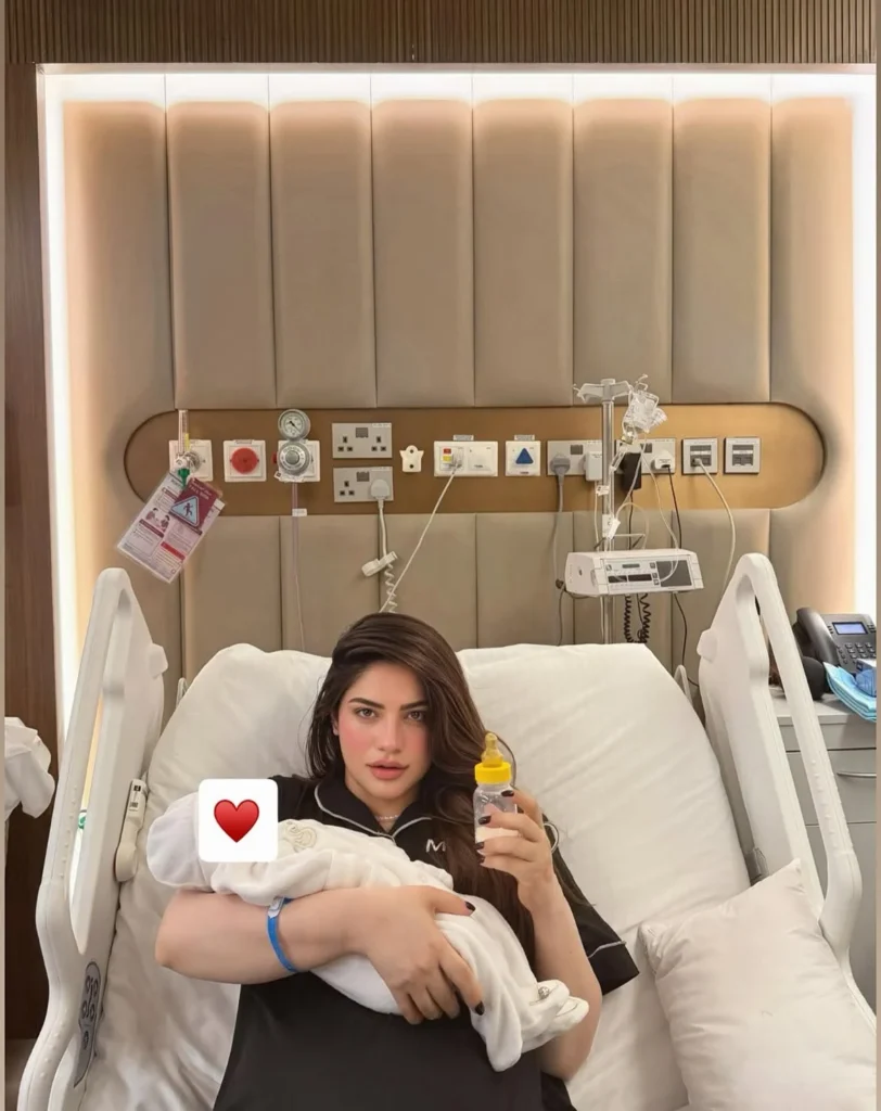 Neelam Muneer Welcomes Baby Boy, Reveals His Name Neelam Muneer holding her newborn son Muhammad Hamdan in a hospital bed.
