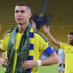 Cristiano Ronaldo celebrates with a Saudi flag scarf after an Al-Nassr match.